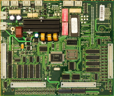The front of the control PCB. On the edges there are four 40-pin connectors for ribbon cables and an army of driver ICs arranged around them. On the top edge there are a bunch of industrial-looking power and/or bus data connectors. Otherwise, the board is dominated by a 100-pin Siemens C509 MCU in the center, a power area with a large heatsink, and a bunch of other components described later in the text.